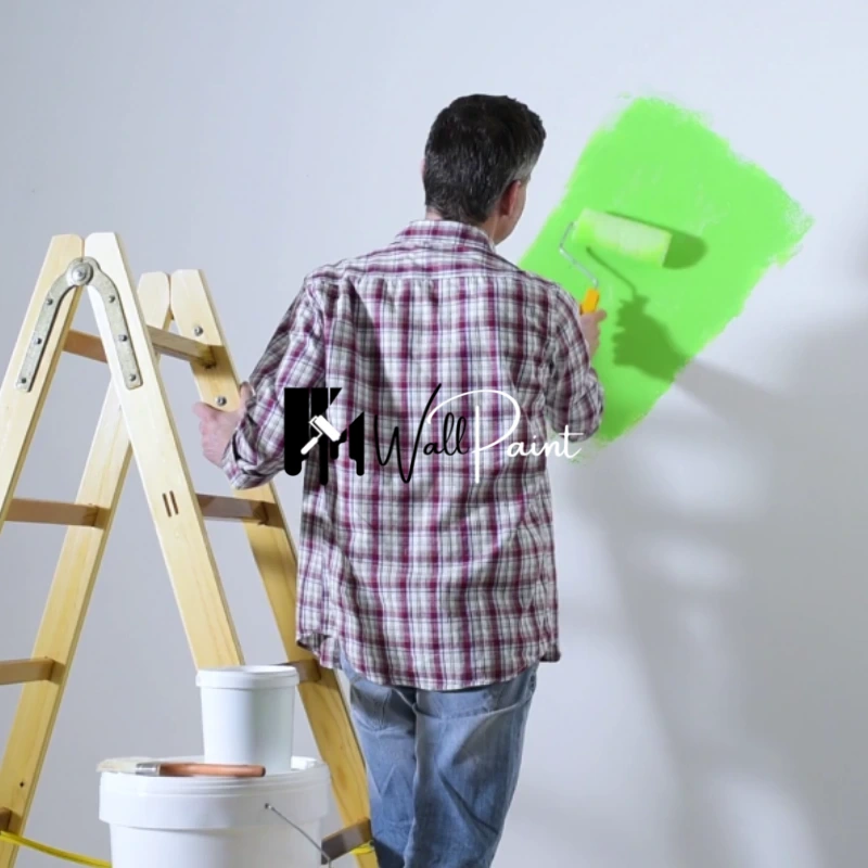 A professional painter adding vibrant green color to a wall in a studio in Dubai.