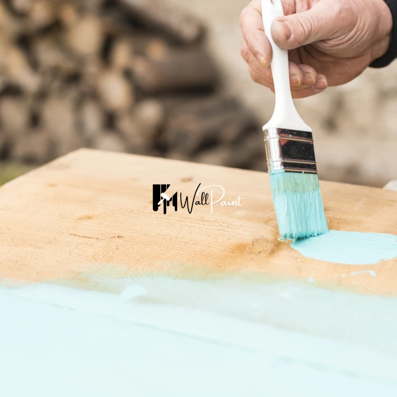 Dubai Furniture Painting_ A person carefully applies white paint to a wooden surface.