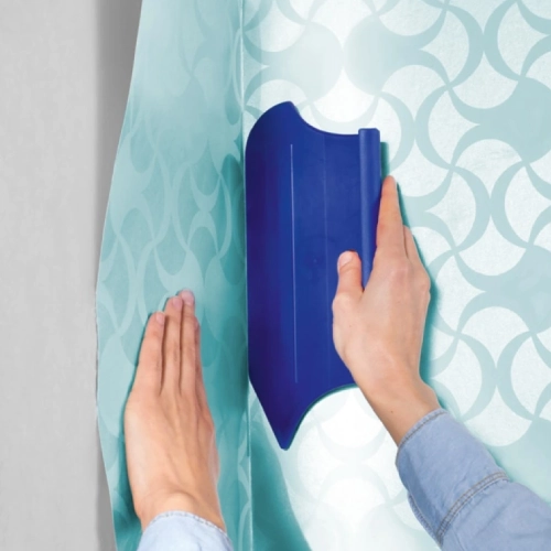 Applying wallpaper with a tool, for professional wallpaper fixing dubai.